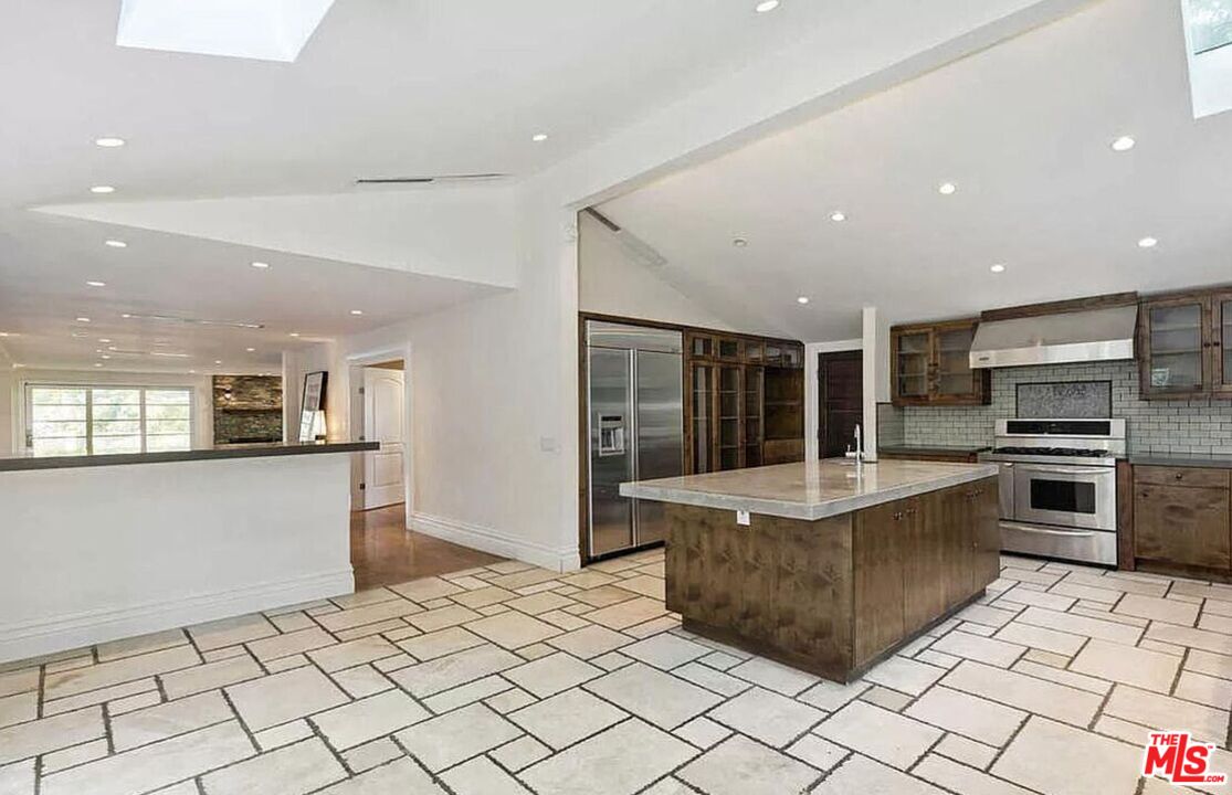 3441 White Rose Way Encino, CA 91436 - Photo 12 of 22 a kitchen with stainless steel appliances kitchen island granite countertop a refrigerator and a sink