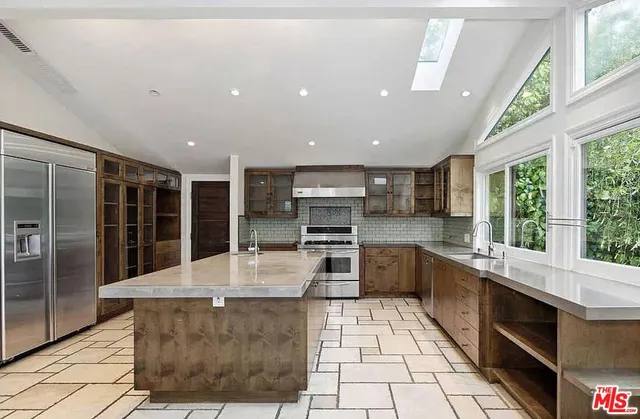 a large kitchen with stainless steel appliances lots of counter space and breakfast area