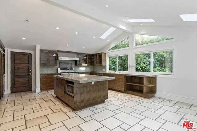 a large kitchen with stainless steel appliances granite countertop a stove and a sink