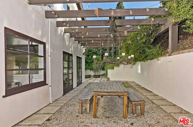 a view of a patio with table and chairs with wooden floor and plants