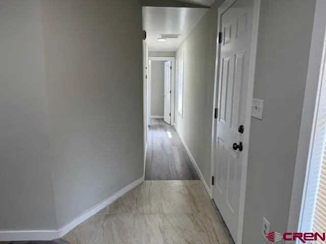 a view of a hallway with wooden floor