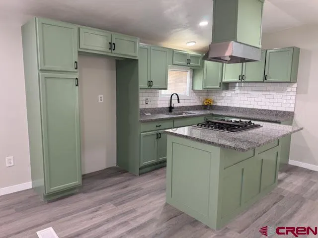 a kitchen with stainless steel appliances granite countertop a stove a sink and a refrigerator