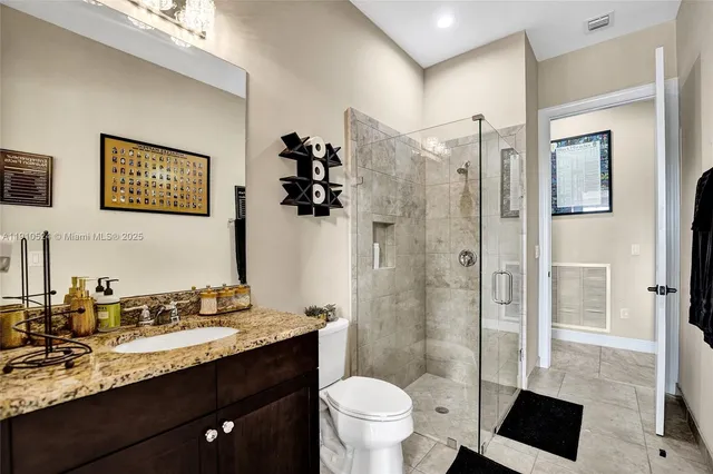 a bathroom with a granite countertop sink toilet and shower