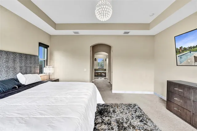 a bedroom with a bed and a lamp on dresser