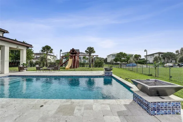 a view of swimming pool with outdoor seating and yard in back