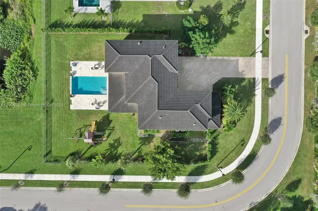 an aerial view of a house with a garden and yard