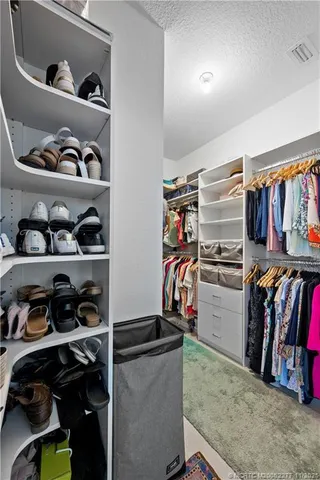 a view of walk in closet with clothes