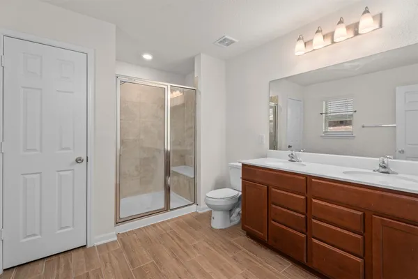 a bathroom with a double vanity sink toilet and shower