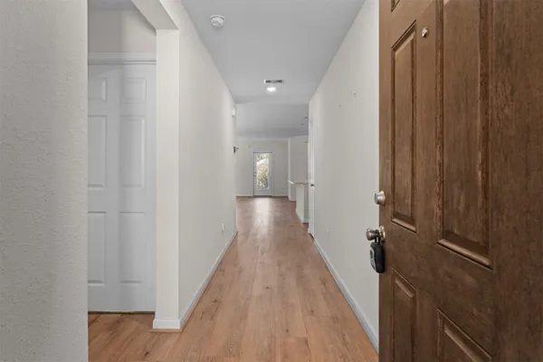 a view of a hallway with wooden floor and staircase