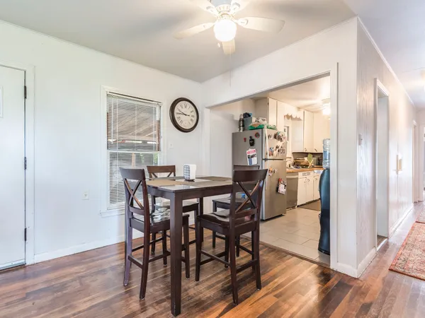 a view of a dining room and livingroom with furniture wooden floor a chandelier