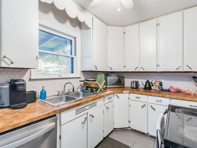 a kitchen with white cabinets and sink