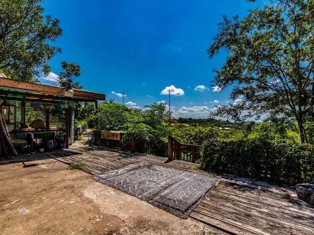 a view of a patio with table and chairs under an umbrella with potted plants