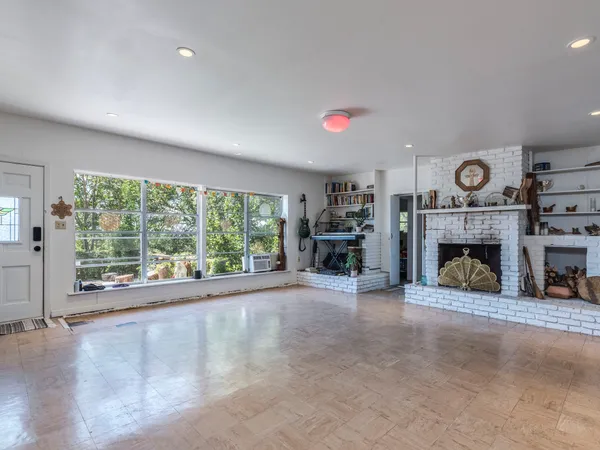 a view of an empty room with a fireplace and a large window