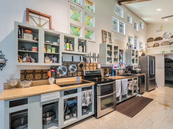 a kitchen with stainless steel appliances granite countertop a stove top oven a sink and a refrigerator