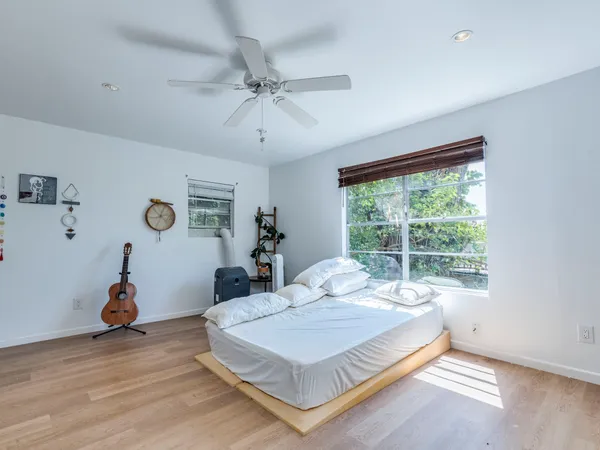 a bedroom with a bed a chandelier and a window