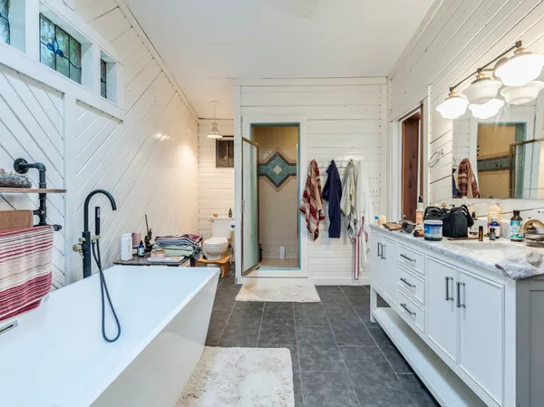 a kitchen with stainless steel appliances kitchen island granite countertop a sink and white cabinets