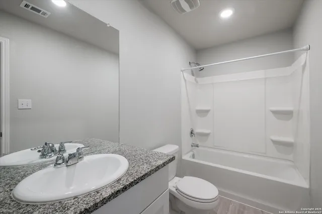 a bathroom with a granite countertop sink toilet and shower