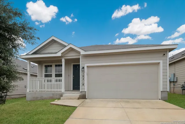 a front view of a house with a yard and a garage
