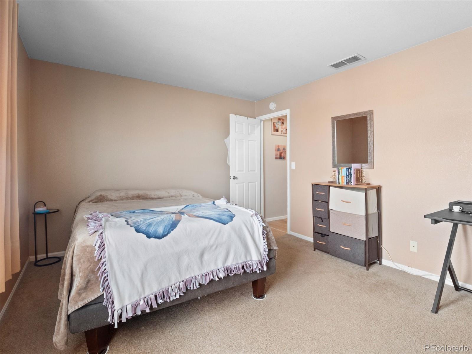 9323 Welby Road Denver, CO 80229 - Photo 18 of 40 a bedroom with a bed and a desk