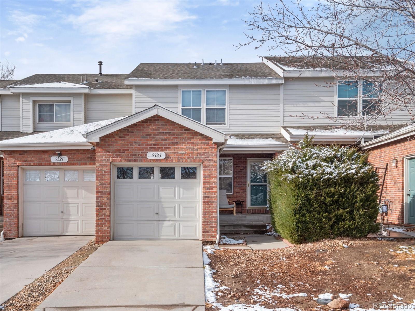 9323 Welby Road Denver, CO 80229 - Photo 2 of 40 a view of a white house with large windows and a small yard
