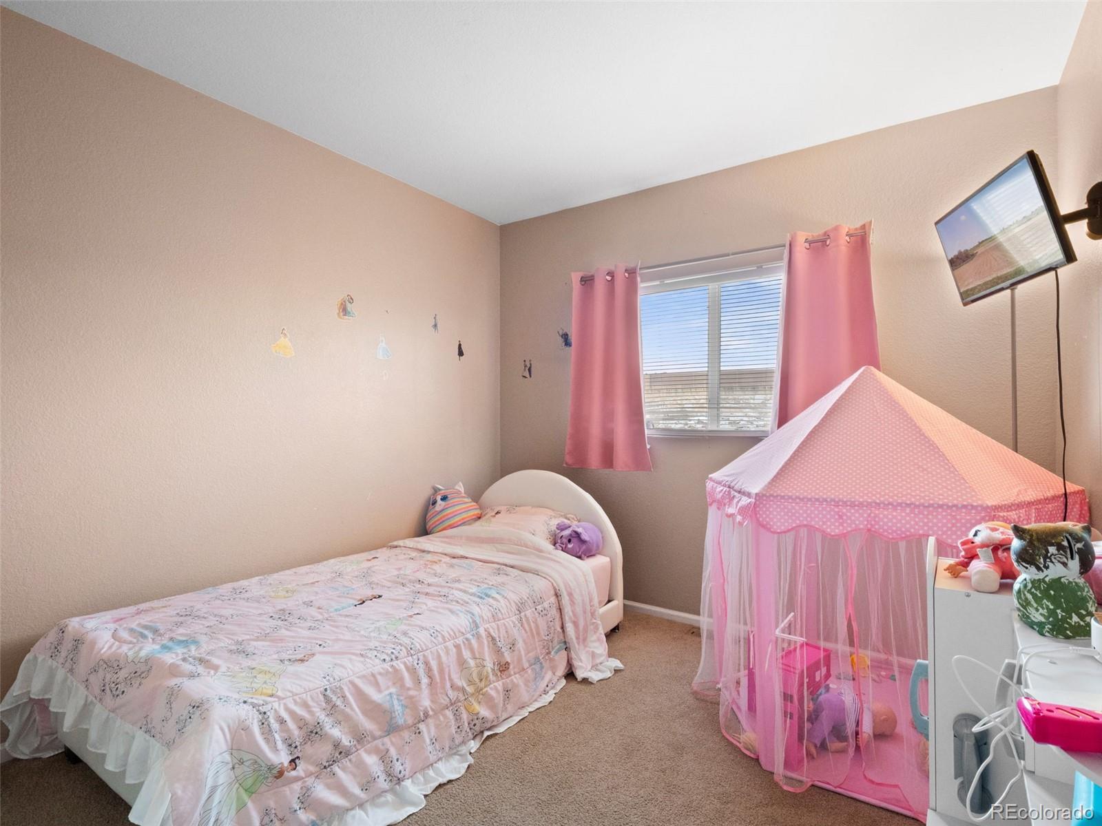 9323 Welby Road Denver, CO 80229 - Photo 23 of 40 a bedroom with a bed and a window