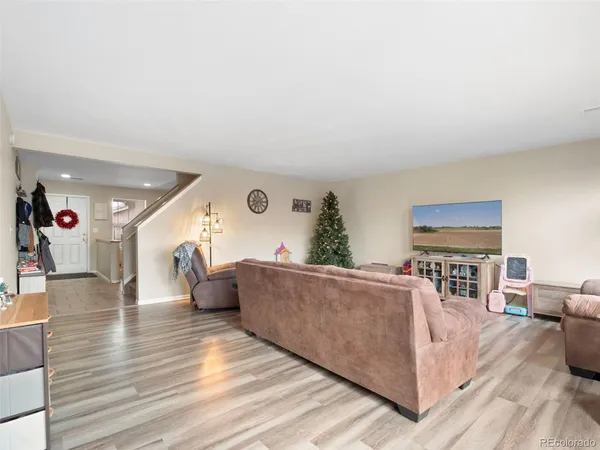 a living room with furniture and a wooden floor