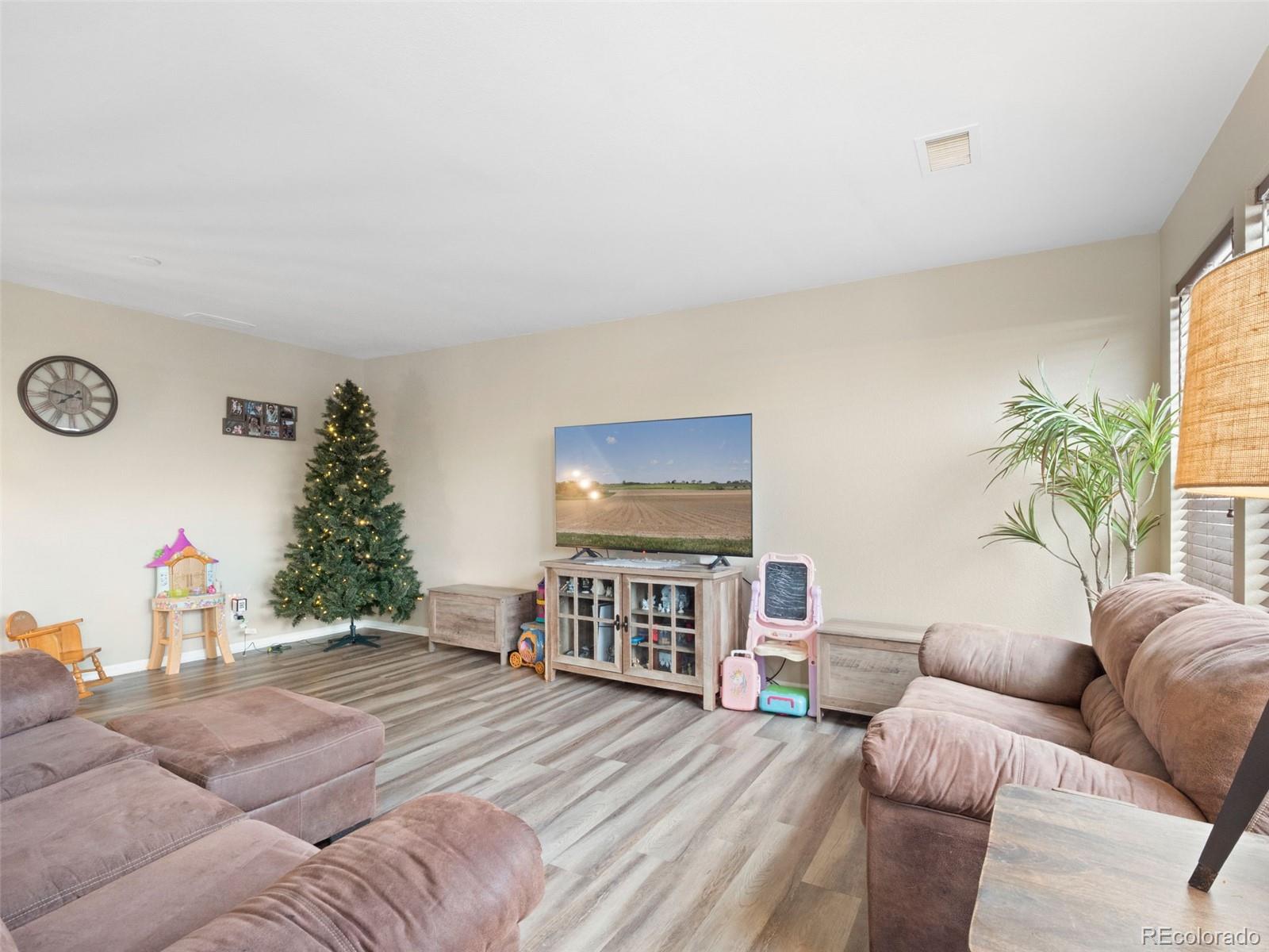 9323 Welby Road Denver, CO 80229 - Photo 32 of 40 a living room with furniture and a flat screen tv