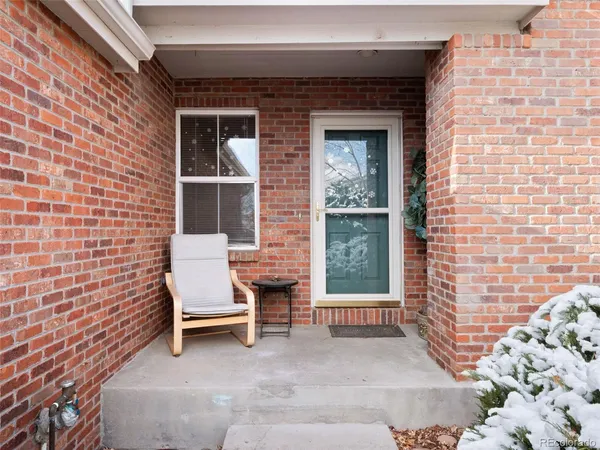 a view of a chair and table in the back yard of the house