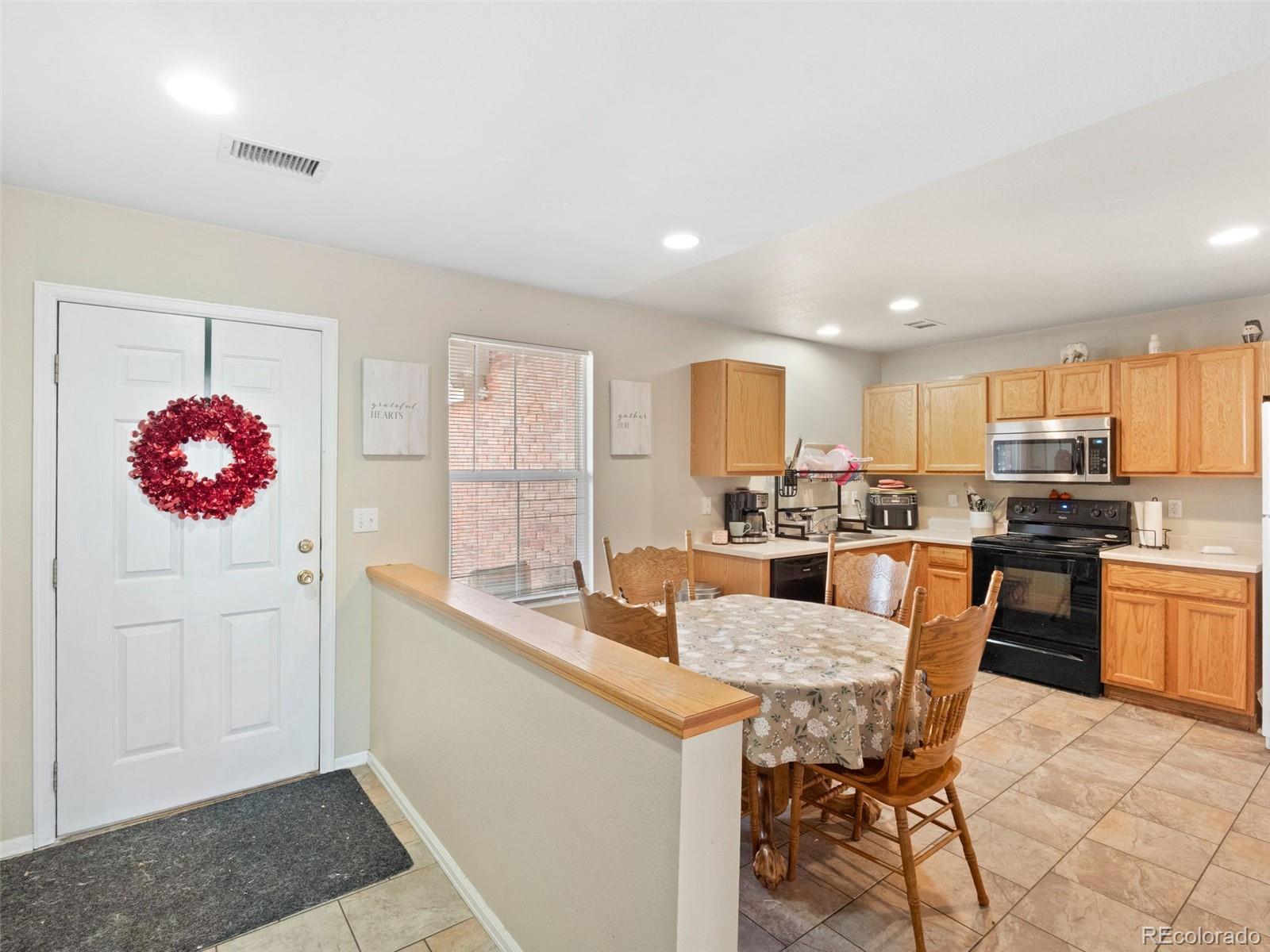 9323 Welby Road Denver, CO 80229 - Photo 5 of 40 a kitchen with a refrigerator and a sink
