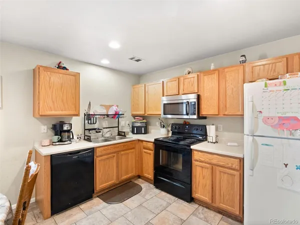 a kitchen with a sink stove top oven and refrigerator