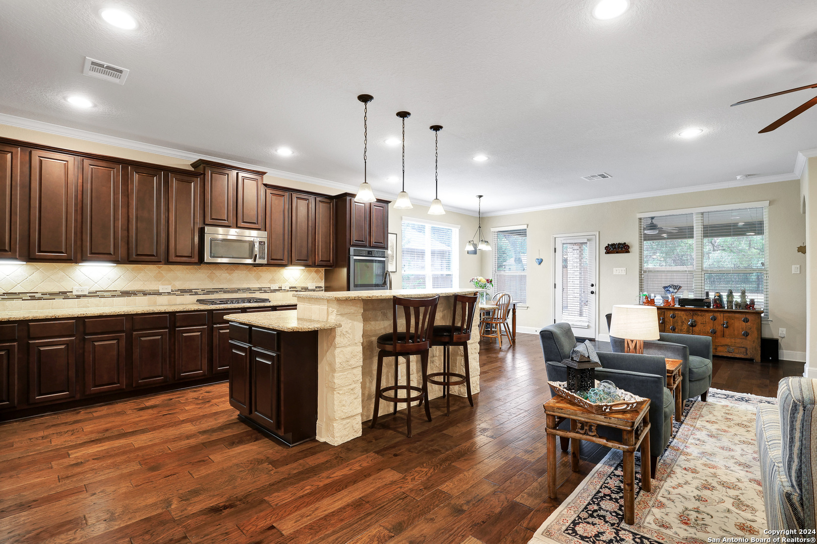 28565 Willis Ranch San Antonio, TX 78260 - Photo 6 of 39 a kitchen with kitchen island granite countertop wooden floors and a view of living room