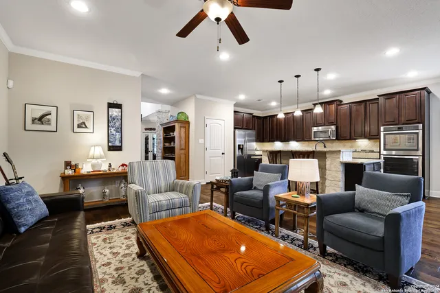 a living room with furniture kitchen view and a chandelier