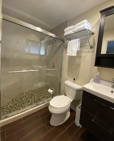 a bathroom with a sink a toilet a mirror and shower