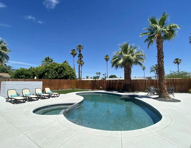 a view of a swimming pool with a patio and a yard