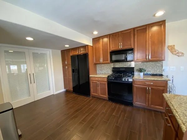 a kitchen with stainless steel appliances granite countertop a stove a sink and a refrigerator