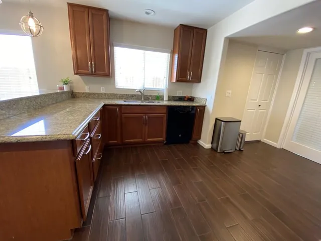 a kitchen with granite countertop wooden floors and a sink