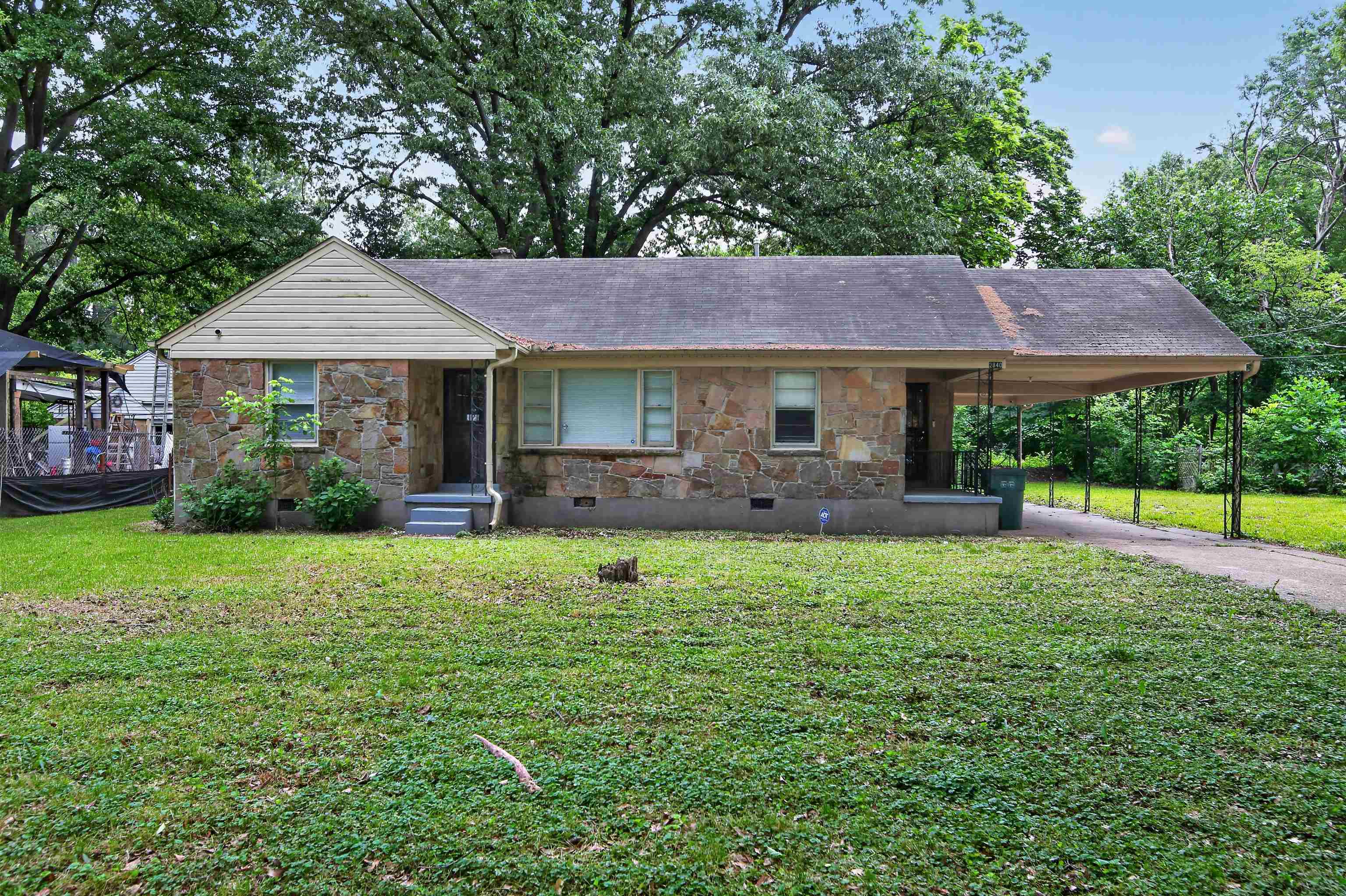 2840 Allen Road Memphis, TN 38128 - Photo 6 of 31 Stone-clad home with an attached carport, featuring a gabled roofline and multiple windows