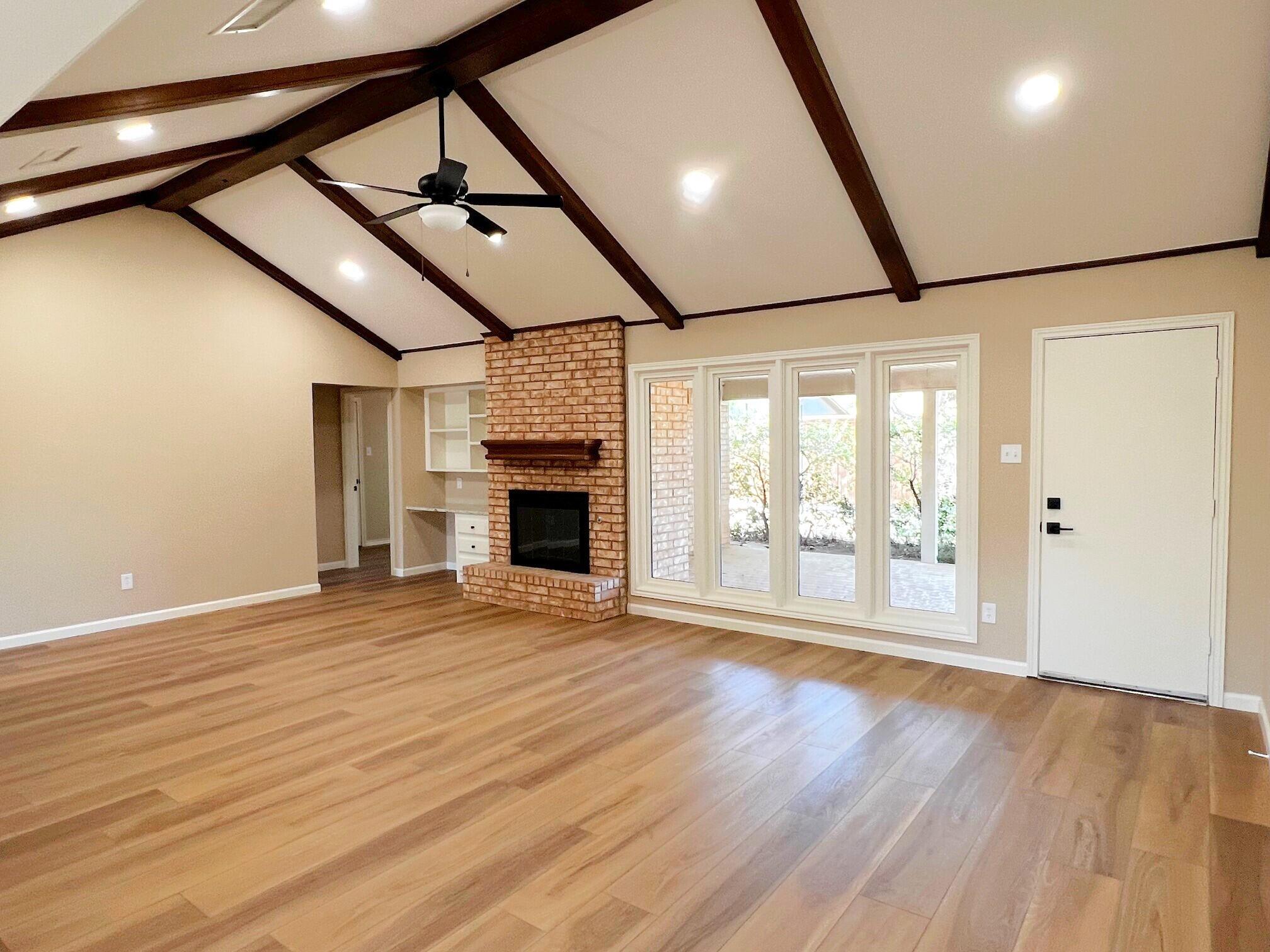 3506 86th Street Lubbock, TX 79423 - Photo 11 of 29 a view of an empty room with wooden floor fireplace and a window
