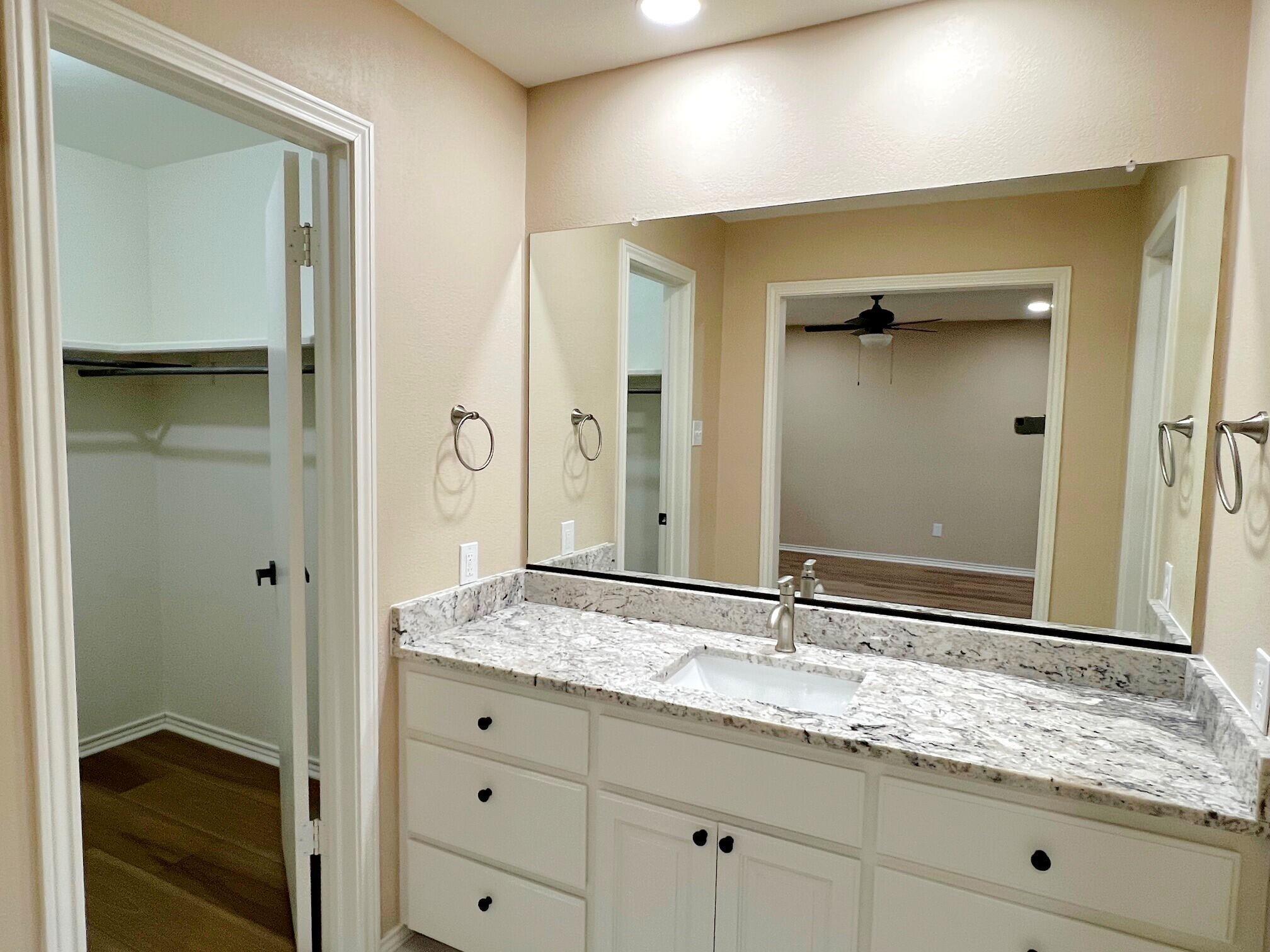 3506 86th Street Lubbock, TX 79423 - Photo 13 of 29 a bathroom with a granite countertop sink and a mirror