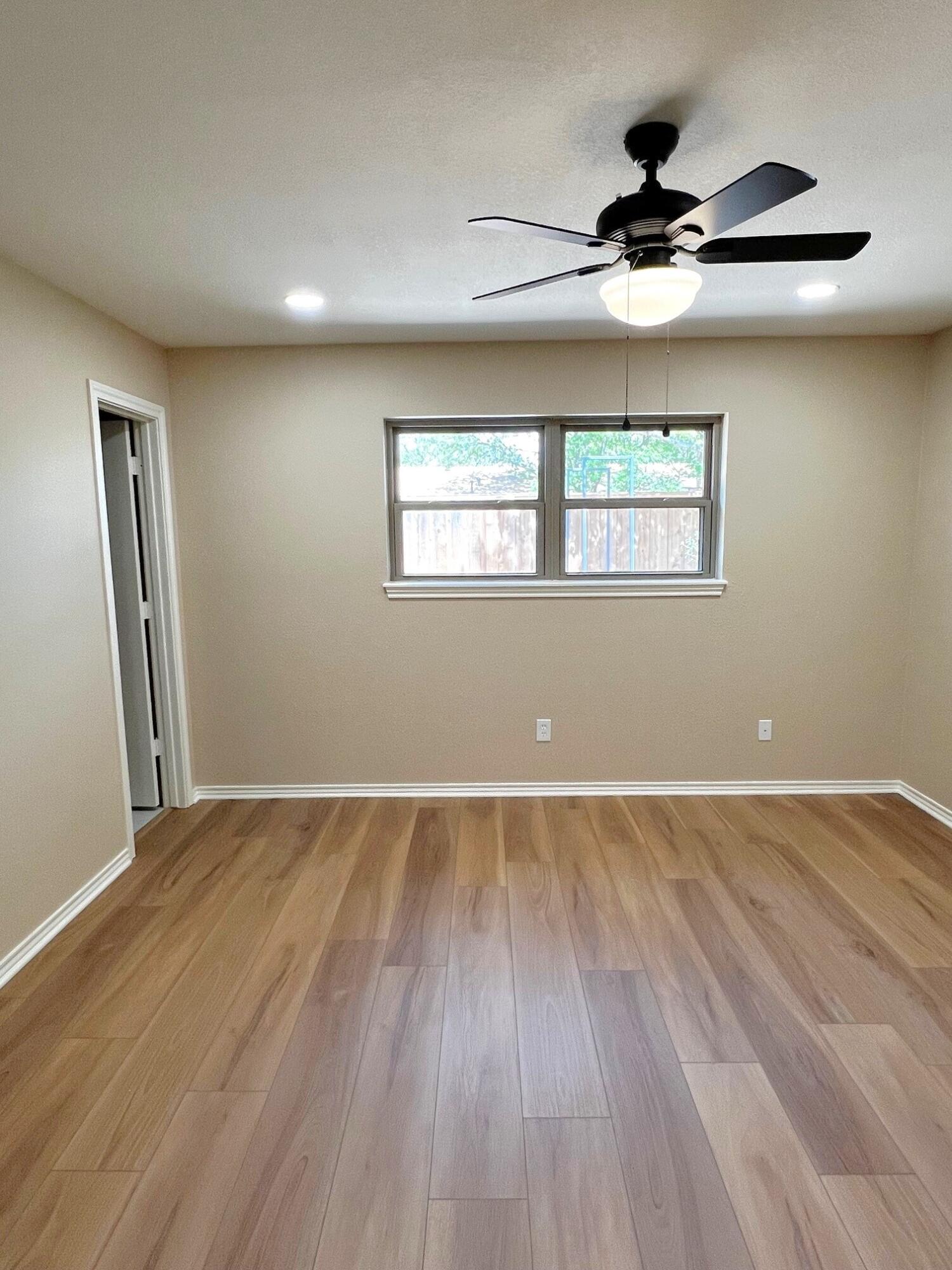 3506 86th Street Lubbock, TX 79423 - Photo 16 of 29 wooden floor in an empty room with a window