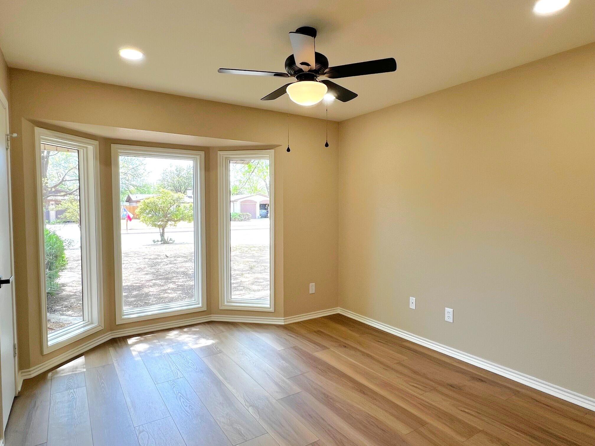 3506 86th Street Lubbock, TX 79423 - Photo 20 of 29 an empty room with wooden floor and windows