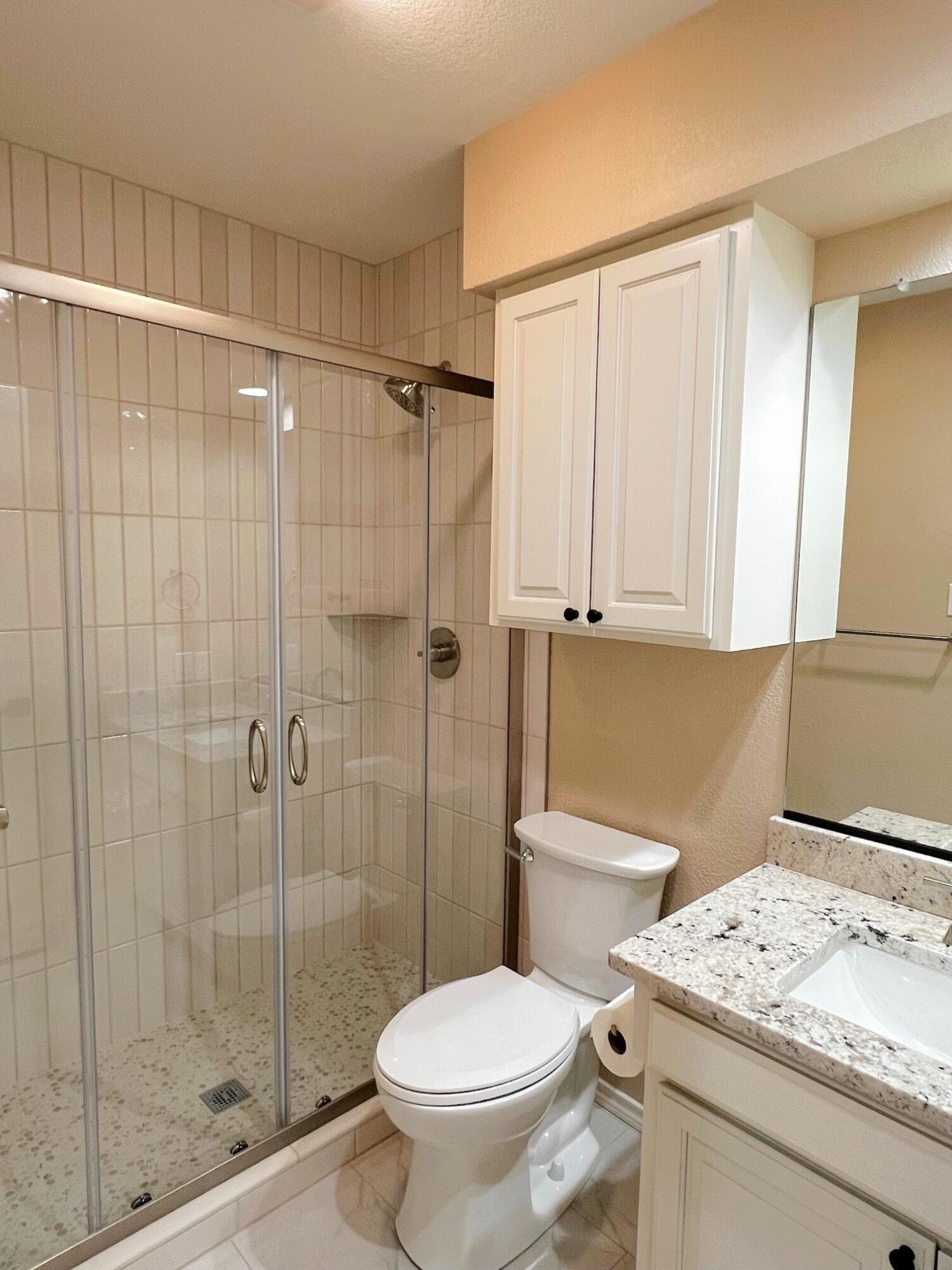 3506 86th Street Lubbock, TX 79423 - Photo 22 of 29 a bathroom with a granite countertop sink a toilet and shower
