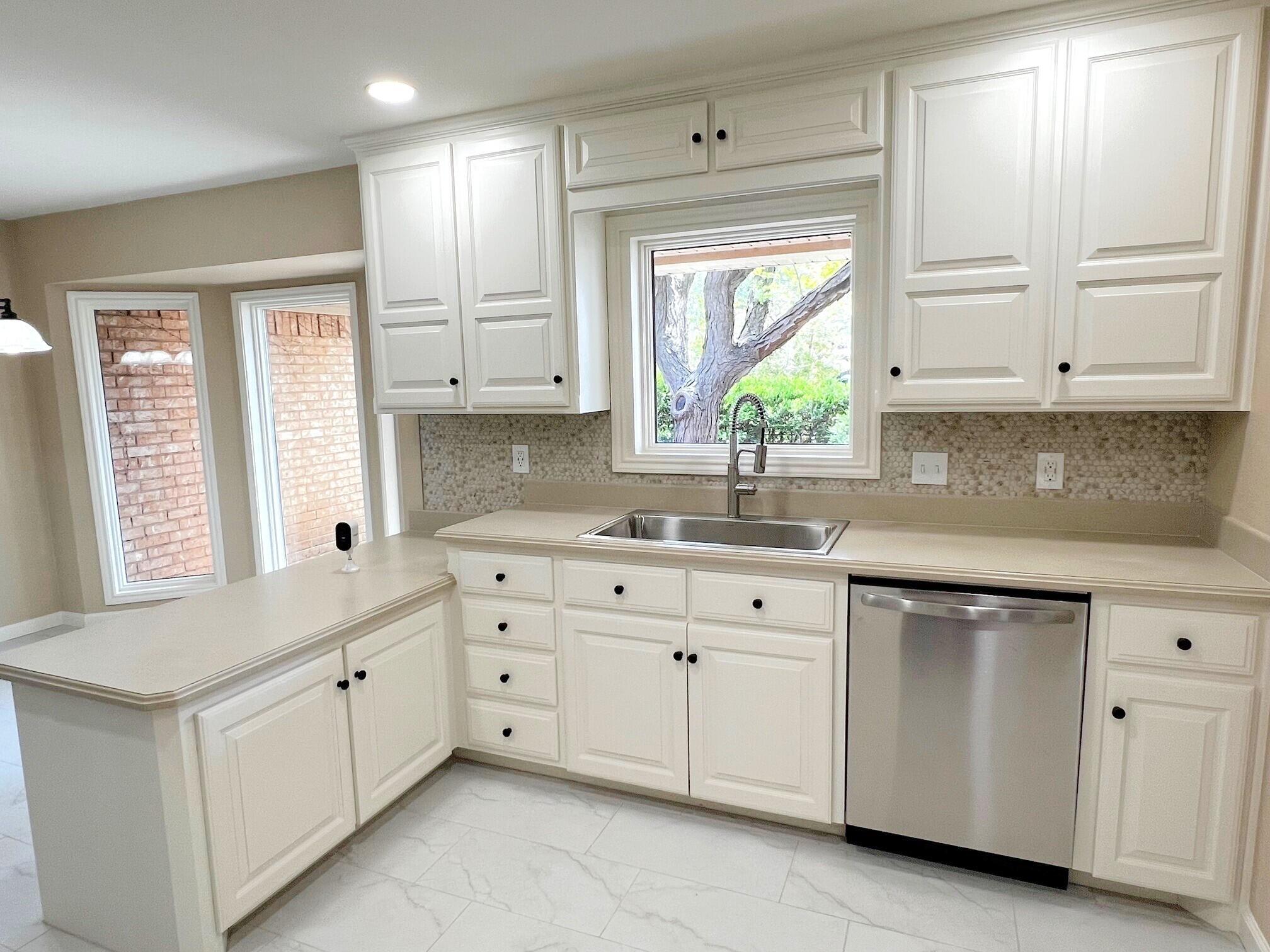 3506 86th Street Lubbock, TX 79423 - Photo 4 of 29 a kitchen with white cabinets and window