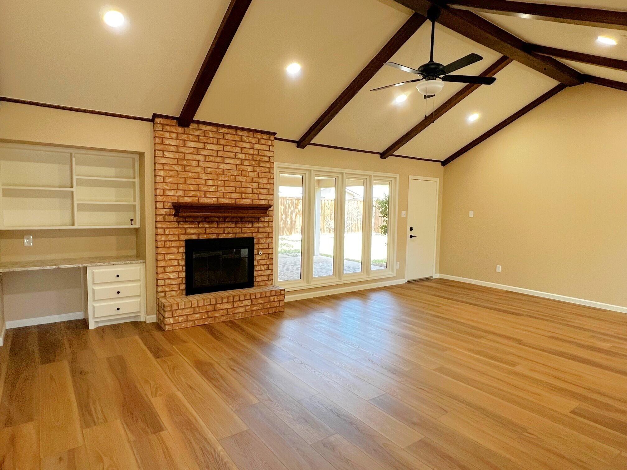 3506 86th Street Lubbock, TX 79423 - Photo 9 of 29 a view of an empty room with wooden floor and a fireplace