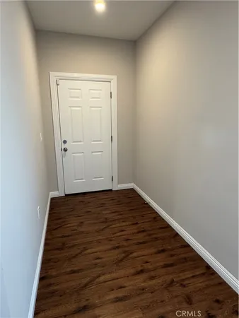 a view of a room with wooden floor and white walls