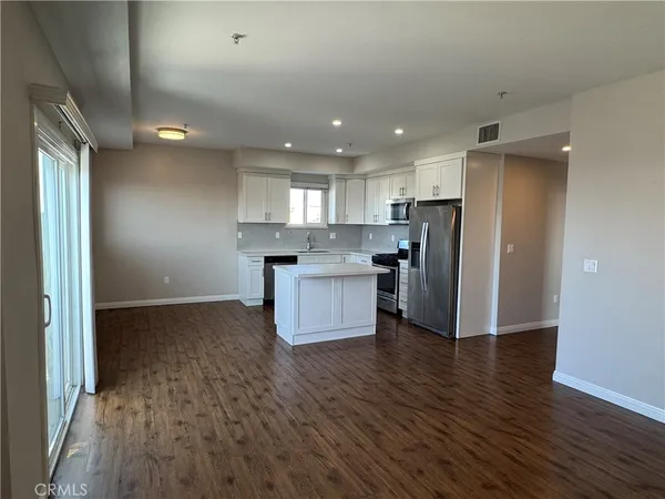 a kitchen with stainless steel appliances granite countertop a refrigerator and a stove top oven