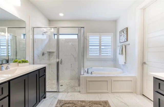 a bathroom with a tub sink shower and mirror