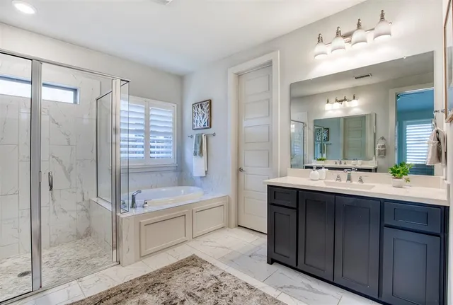 a bathroom with a tub sink shower and mirror