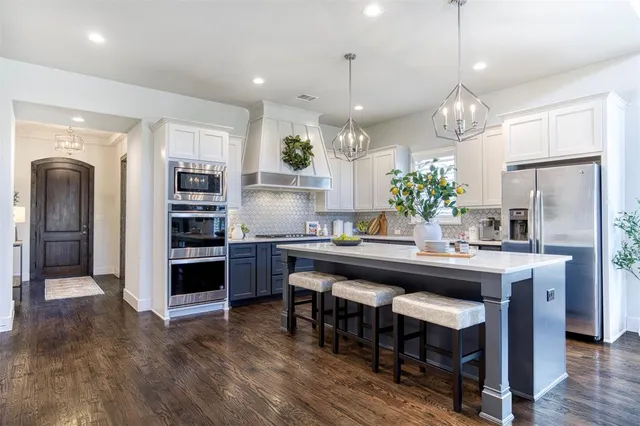 a kitchen with kitchen island granite countertop a sink and refrigerator