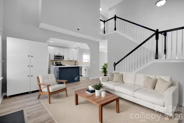 a living room with furniture and kitchen view